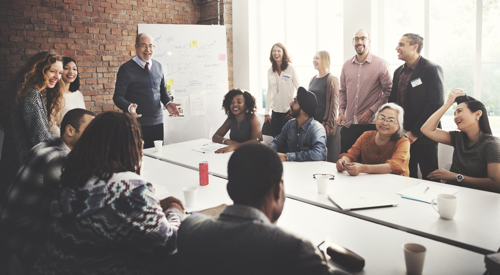 Group of professionals engaged in collaborative discussion around a conference table during a leadership workshop