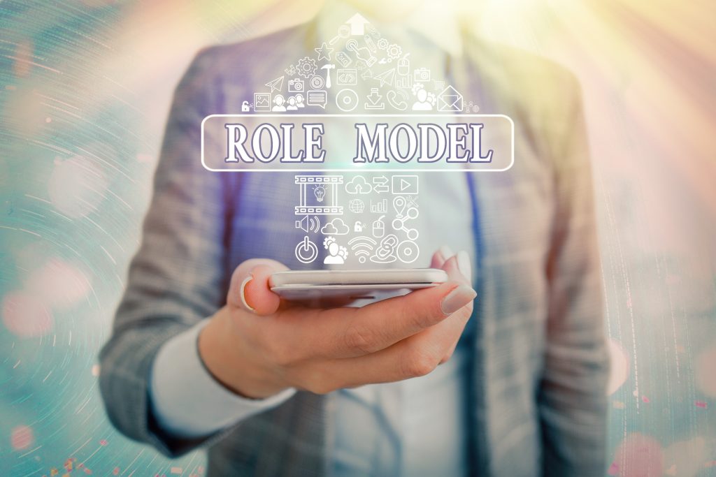 Professional holding smartphone displaying role model concept with organizational hierarchy icons