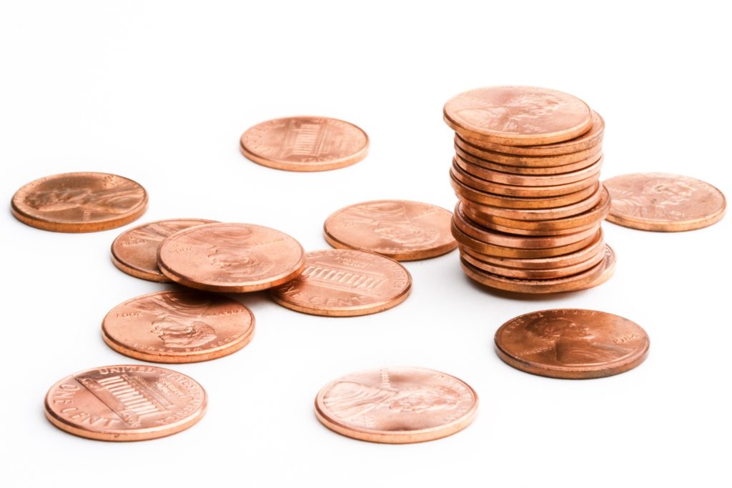 Scattered and stacked pennies representing company value growth through differentiation