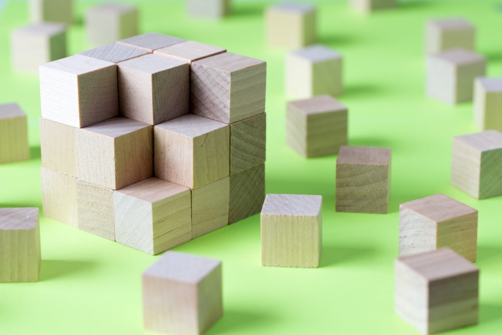 Wooden blocks puzzle assembled showing interconnected structure on bright green background