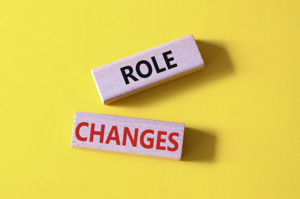 Wooden blocks labeled "ROLE" and "CHANGES" on yellow background illustrating employee role evolution during company growth