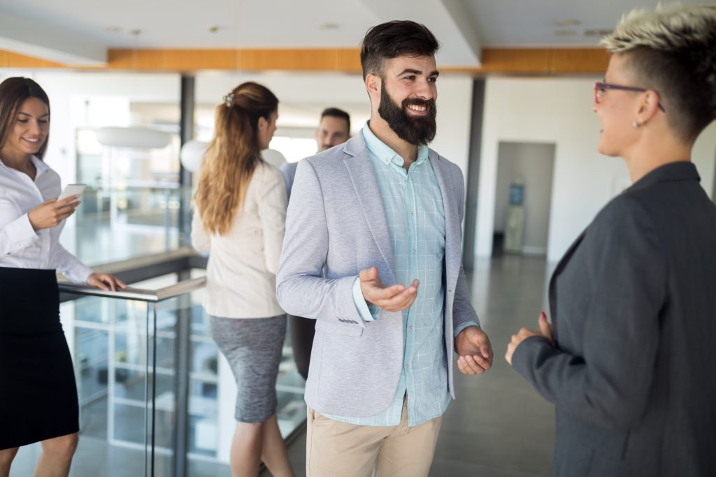 Senior leader engaging with employees in casual office conversation