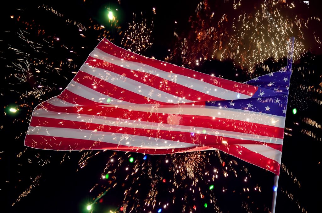 American flag surrounded by fireworks celebrating Independence Day