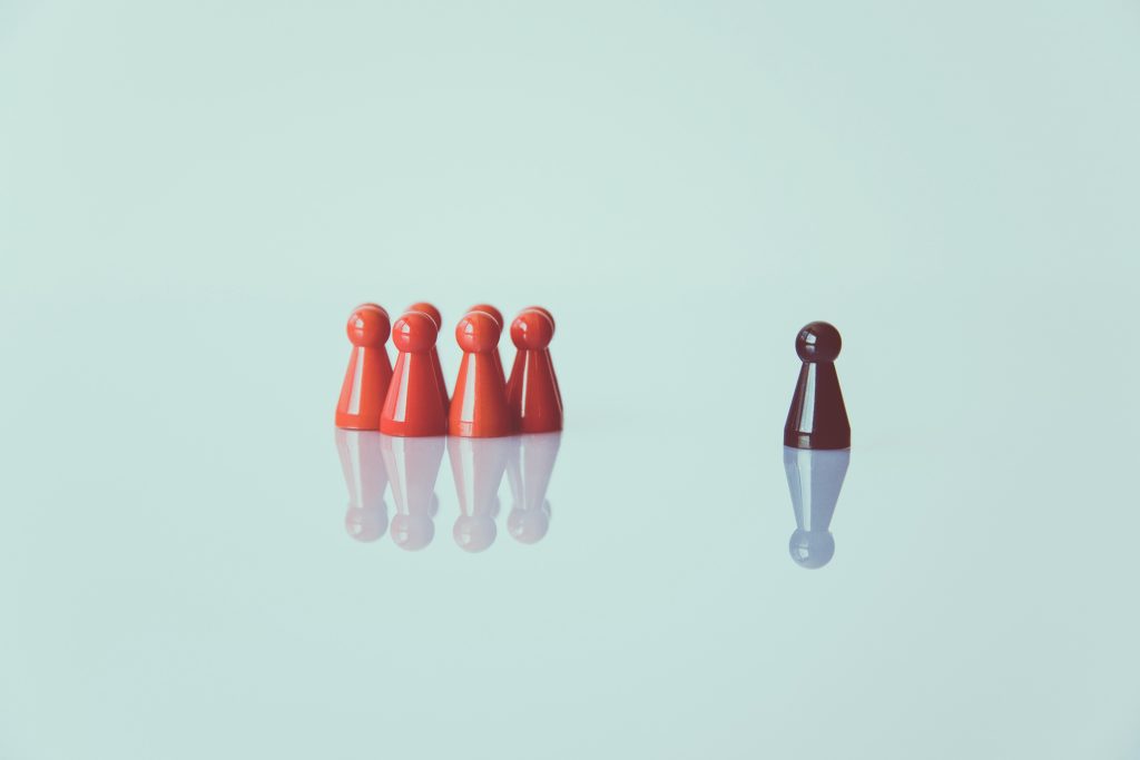 Leadership vision and team alignment concept with individual leader figurine separated from group