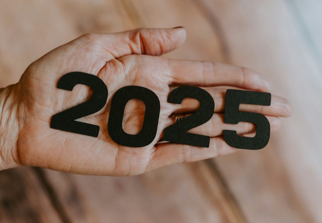 Hand holding black numbers spelling 2025 symbolizing new year business growth and fresh beginnings