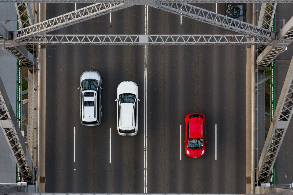 Aerial view of three vehicles on a divided highway, illustrating different paths to efficiency