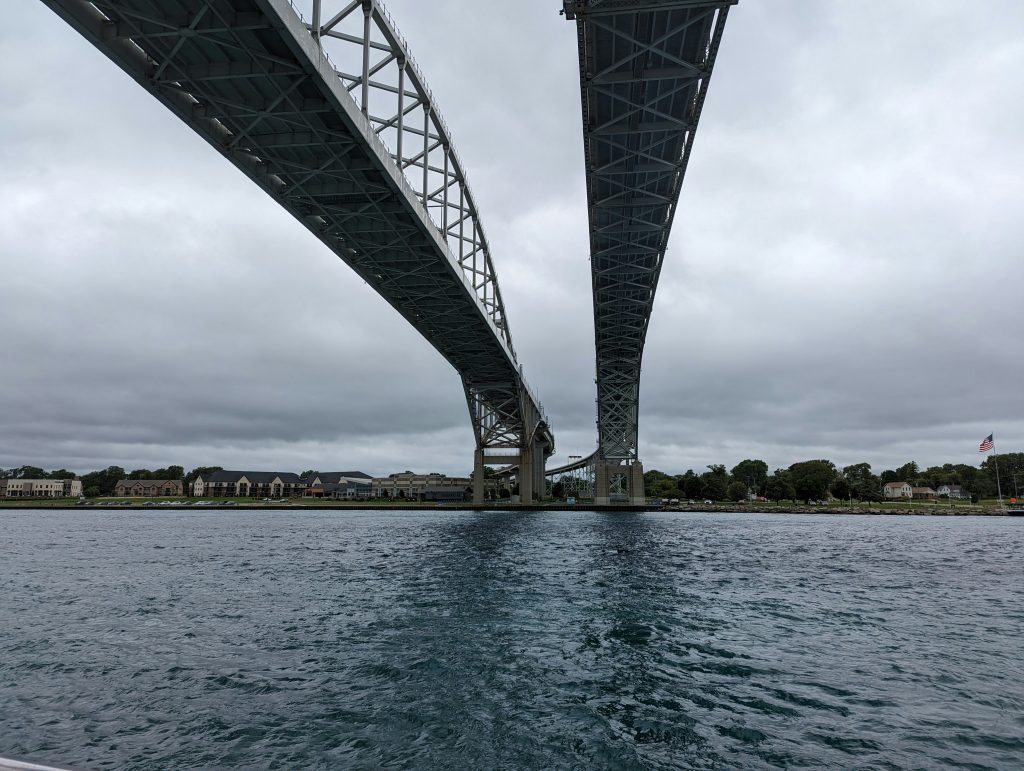 Large bridge spanning water with industrial infrastructure visible below