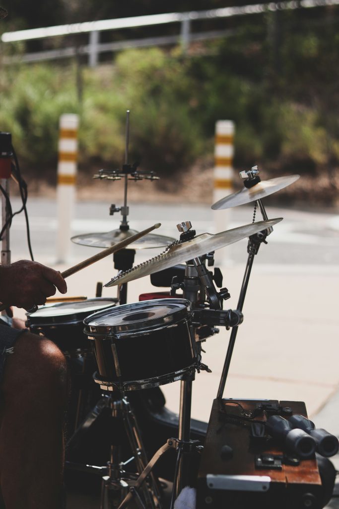 Drummer performing at outdoor venue with professional drum kit and cymbals