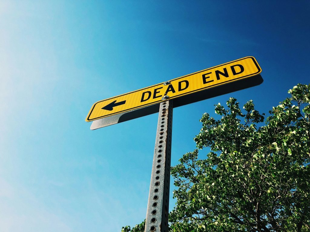 Yellow dead end street sign against clear blue sky, symbolizing leadership without execution