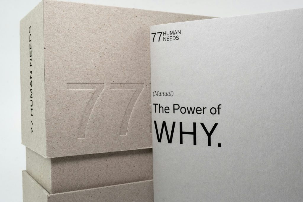 Stacked beige books titled "The Power of WHY" exploring leadership paradigms and questioning assumptions