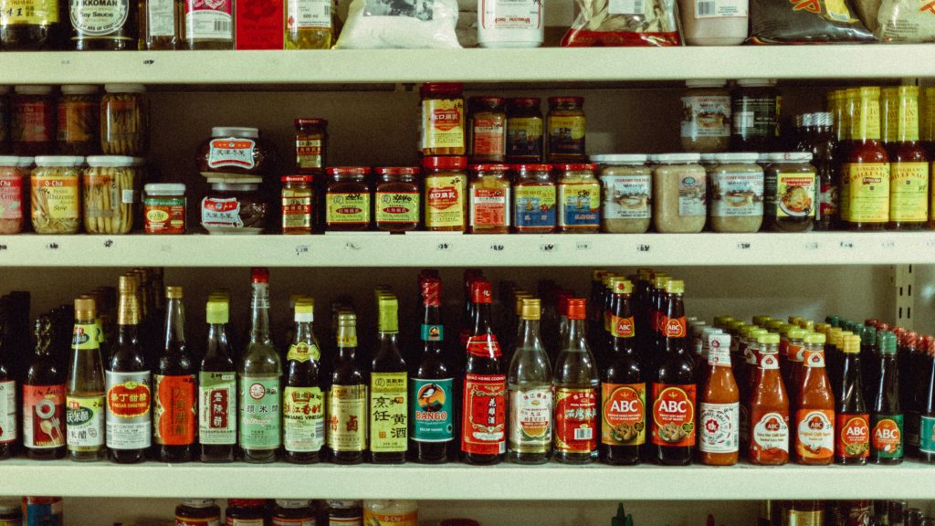 Colorful assortment of bottled sauces and condiments on retail shelves demonstrating product variety and differentiation